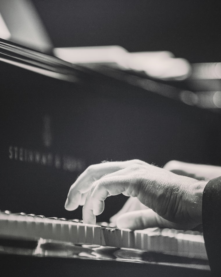 Mains au piano, lumière douce sur un clavier de concert
